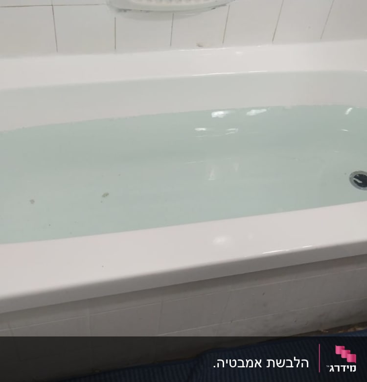 אמבטיה מלאה במים עם אריחים לבנים